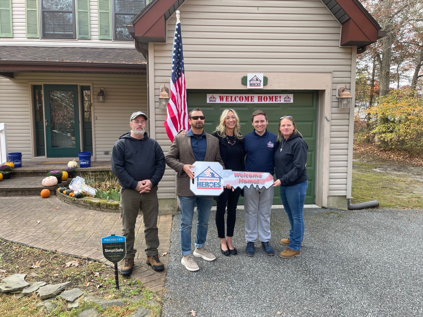 Jack with a Building Homes for Heroes recipient and volunteers holding a Welcome Home key